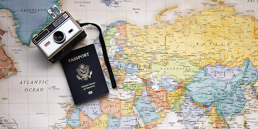 camera and a passport on top of a world map